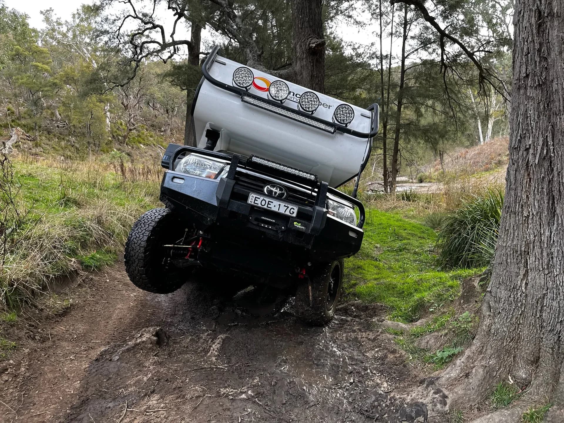 Sherwood Conqueror with drivers wheel airborne climbing a rutted bush track