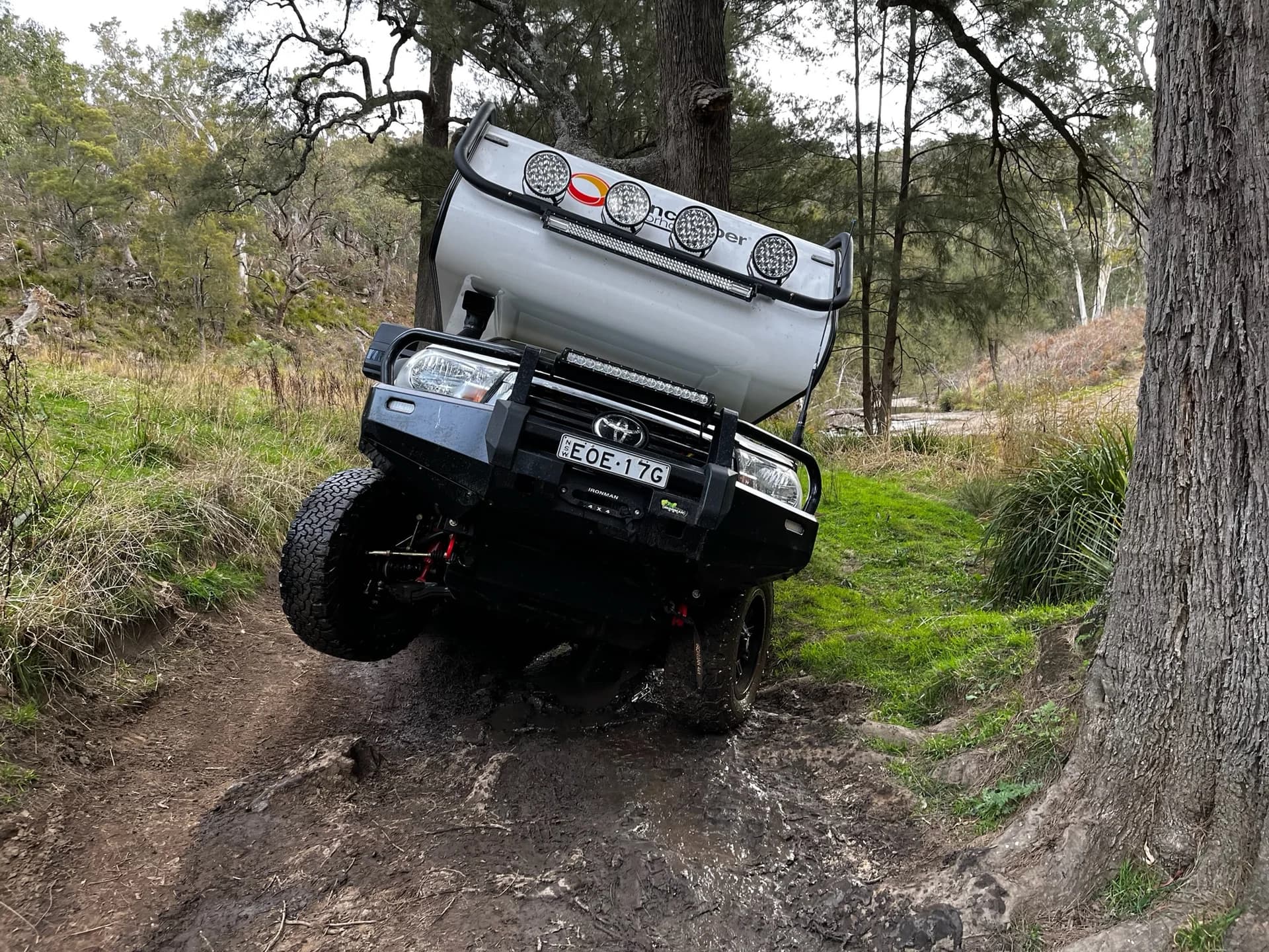 Sherwood Conqueror with drivers wheel airborne climbing a rutted bush track