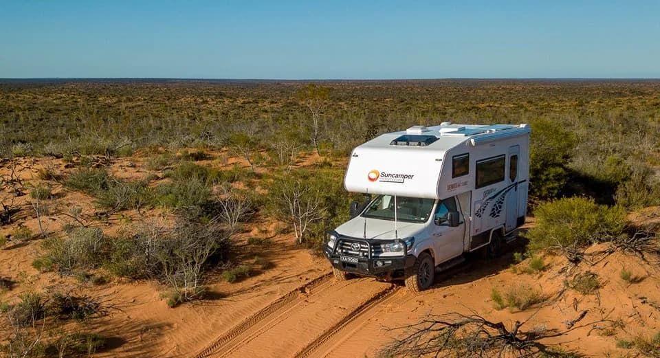 Aerial view of a Sherwood 4x4 on a desert trail with sunny scrub backdrop