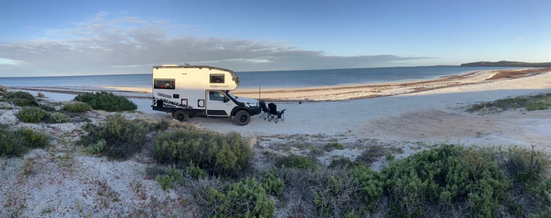 Suncamper on the red sand where it meets the turquoise sea at Francois Peron National Park, Western Australia