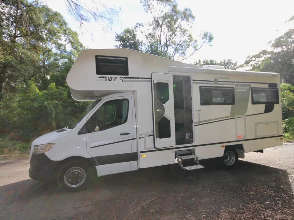 Suncamper Saxby F-2 entry door open with steps deployed — exterior