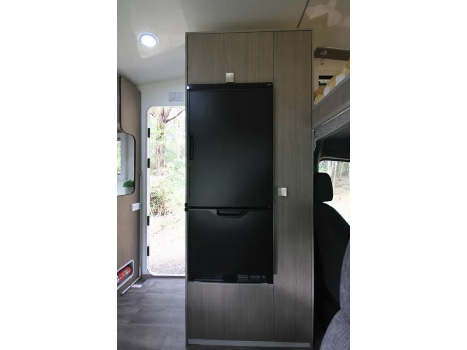 Suncamper Saxby F-2 fridge and storage from entry — kitchen