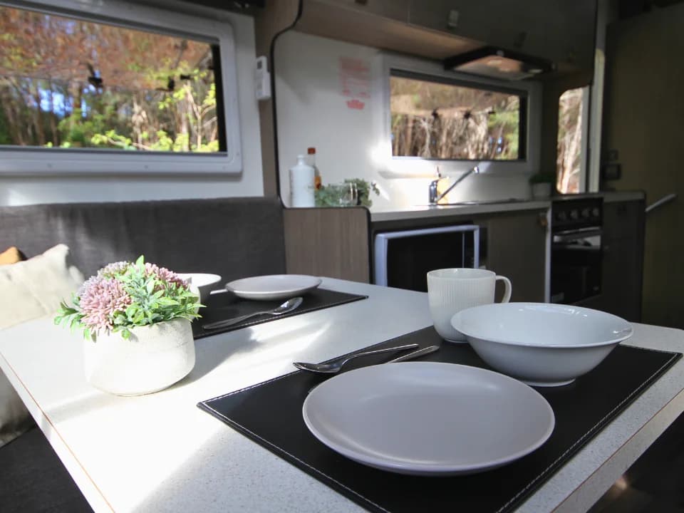 Suncamper Saxby F-2 dining table with place settings — interior